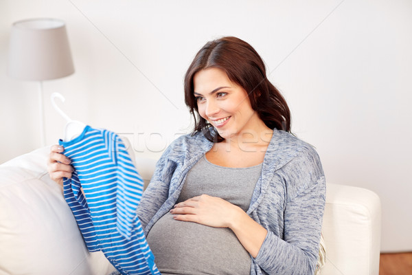 happy woman holding baby boys bodysuit at home Stock photo © dolgachov