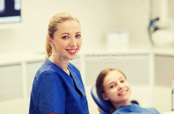 happy female dentist with patient girl at clinic Stock photo © dolgachov