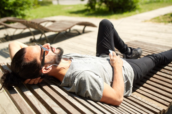 man with earphones and smartphone listening music Stock photo © dolgachov