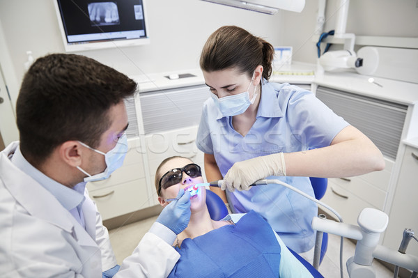 dentists treating male patient teeth at clinic Stock photo © dolgachov
