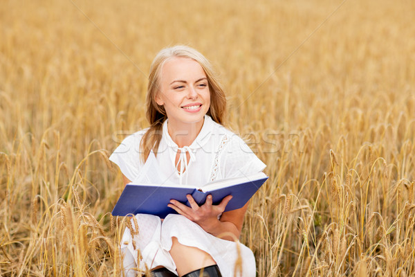 Sorridente mulher jovem leitura livro cereal campo Foto stock © dolgachov
