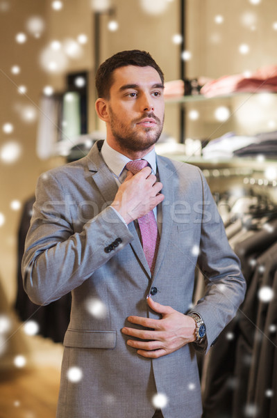 young man trying suit on in clothing store Stock photo © dolgachov