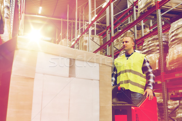 man with tablet pc operating forklift at warehouse Stock photo © dolgachov