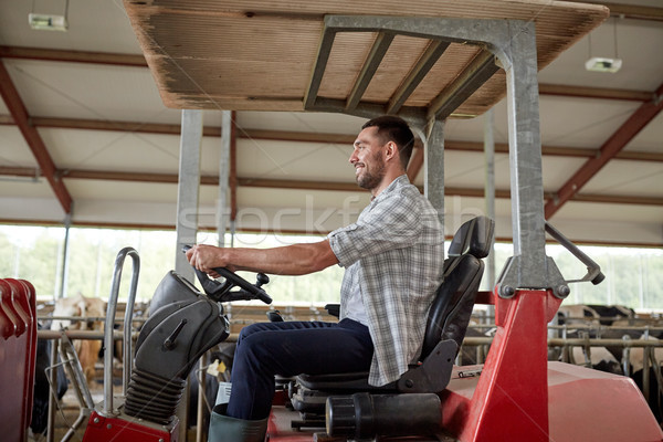 man or farmer driving tractor at farm Stock photo © dolgachov