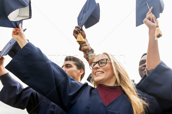 happy students or bachelors waving mortar boards Stock photo © dolgachov
