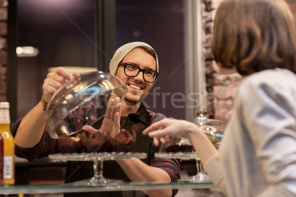 man or barman with cakes serving customer at cafe Stock photo © dolgachov