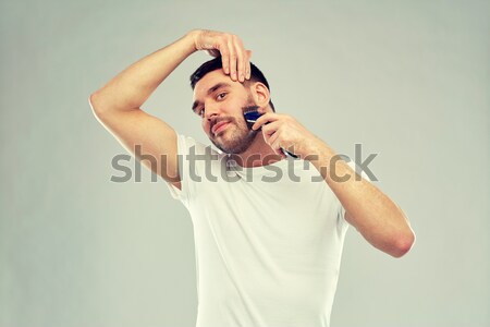 young making gallows gesture over gray background Stock photo © dolgachov