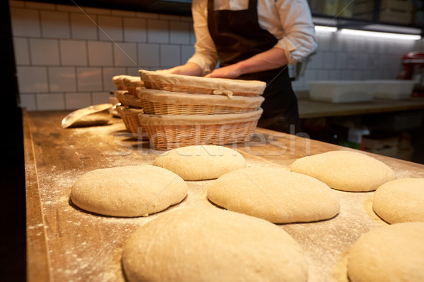 baker with baskets for dough rising at bakery Stock photo © dolgachov
