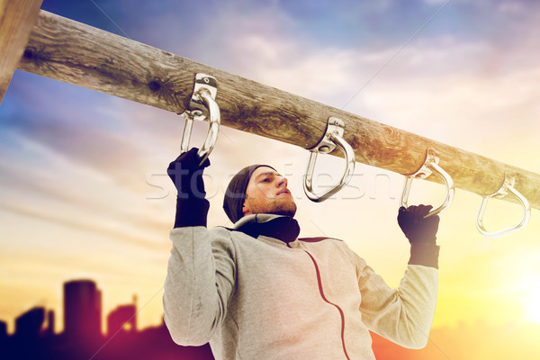 young man exercising on horizontal bar in winter Stock photo © dolgachov