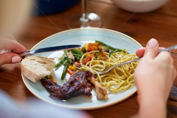 hands of woman eating pasta and roast chicken Stock photo © dolgachov