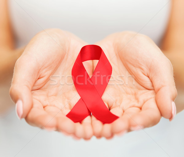 Stock photo: hands holding red AIDS awareness ribbon