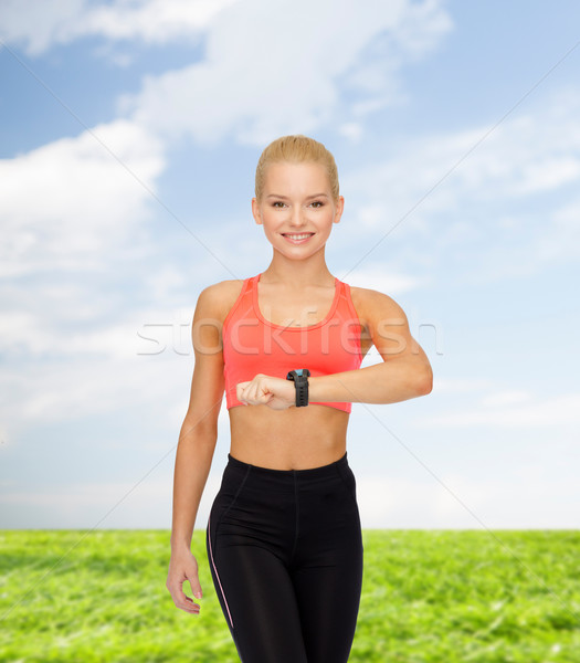 Donna sorridente frequenza cardiaca monitor mano fitness tecnologia Foto d'archivio © dolgachov