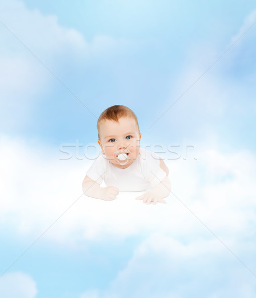 smiling baby lying on cloud with dummy in mouth Stock photo © dolgachov
