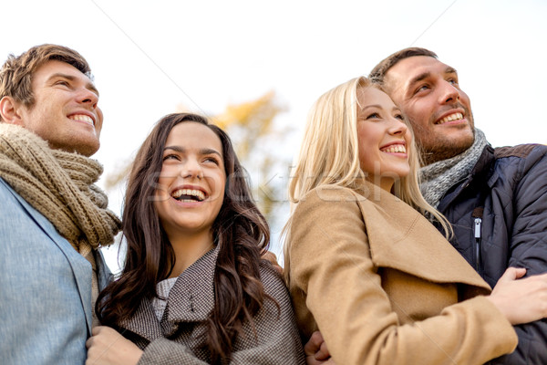 group of smiling men and women in autumn park Stock photo © dolgachov
