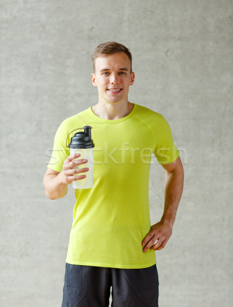 Mosolyog férfi fehérje shake üveg sport Stock fotó © dolgachov
