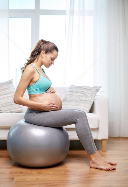 Stock photo: happy pregnant woman exercising on fitball at home