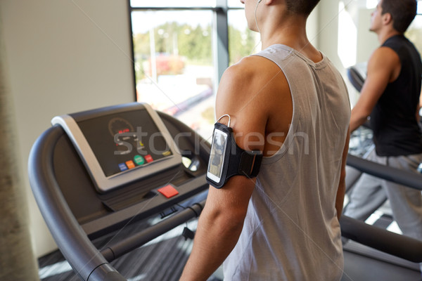 Stock photo: smiling men exercising on treadmill in gym