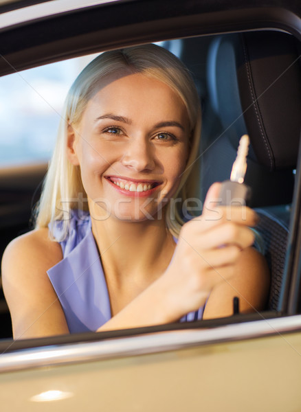 Stock photo: happy woman getting car key in auto show or salon