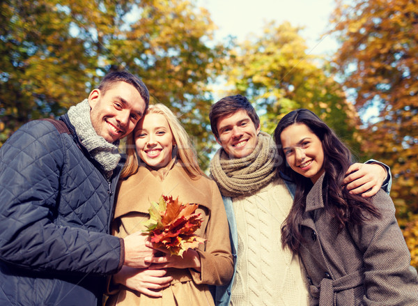 group of smiling men and women in autumn park Stock photo © dolgachov