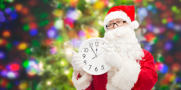 man in costume of santa claus with clock Stock photo © dolgachov
