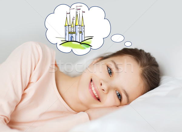 smiling girl lying in bed and dreaming of castle Stock photo © dolgachov