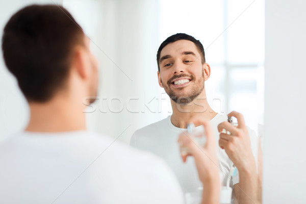 Człowiek perfum patrząc lustra łazienka perfumeria Zdjęcia stock © dolgachov