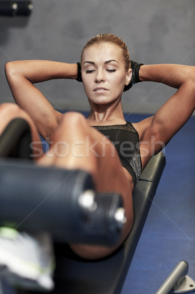 woman flexing abdominal muscles on bench in gym Stock photo © dolgachov