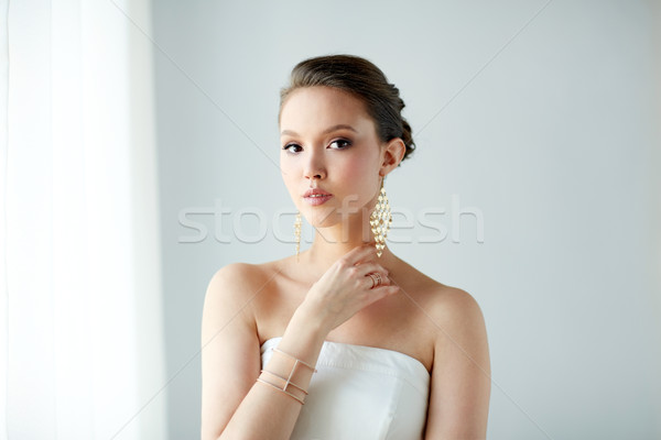 beautiful asian woman with earrings and bracelet Stock photo © dolgachov