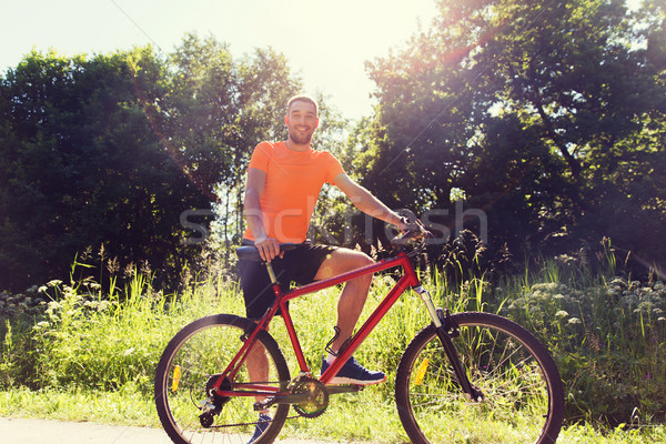 happy young man riding bicycle outdoors Stock photo © dolgachov