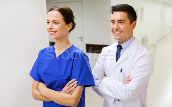 smiling doctor in white coat and nurse at hospital Stock photo © dolgachov