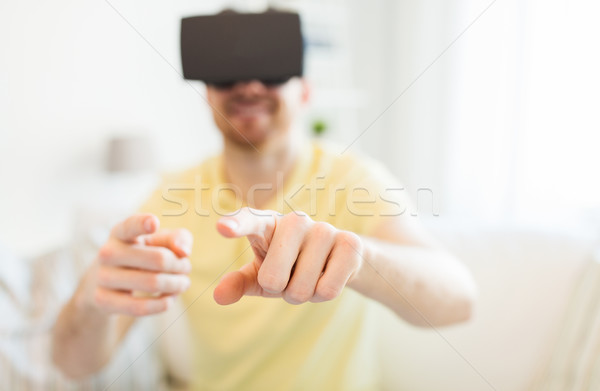 young man in virtual reality headset or 3d glasses Stock photo © dolgachov