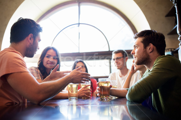 Stock photo: happy friends drinking beer at bar or pub