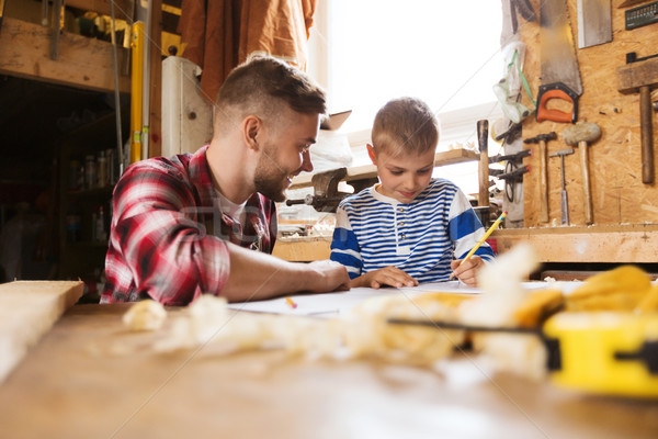 happy father and son with blueprint at workshop Stock photo © dolgachov