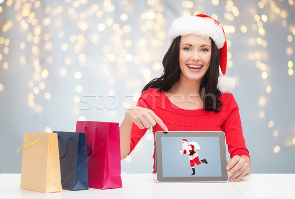 woman in santa hat with tablet pc and shopping bag Stock photo © dolgachov
