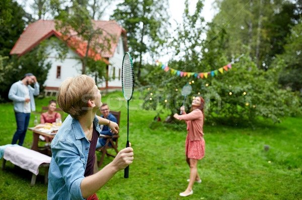 happy friends playing badminton at summer garden Stock photo © dolgachov