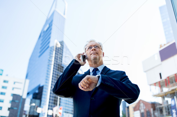 Stock photo: senior businessman calling on smartphone in city