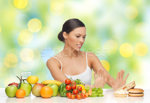 woman with fruits rejecting fast food on table Stock photo © dolgachov