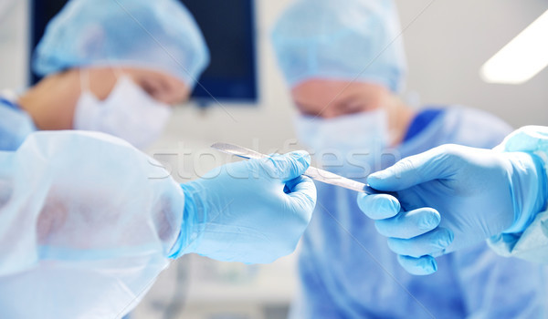 Stock photo: close up of hands with scalpel at operation