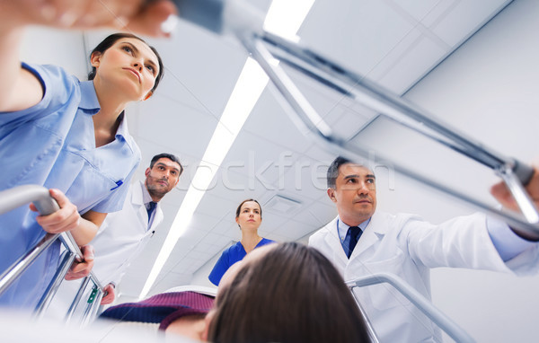 Stock photo: medics with woman on hospital gurney at emergency