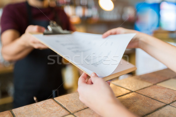 bartender showing menu to customer at bar Stock photo © dolgachov