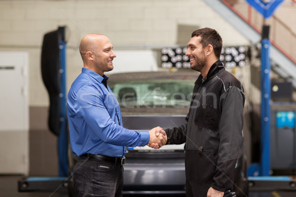 mechanic and customer shaking hands at car service Stock photo © dolgachov