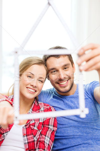 Stock photo: smiling couple with house from measuring tape