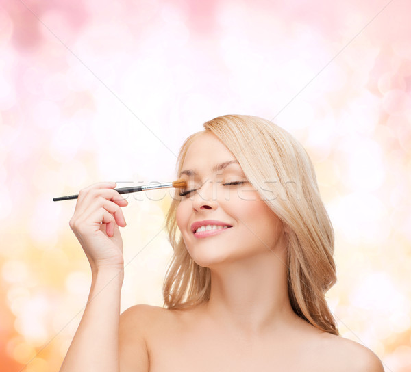 beautiful woman with closed eyes and makeup brush Stock photo © dolgachov