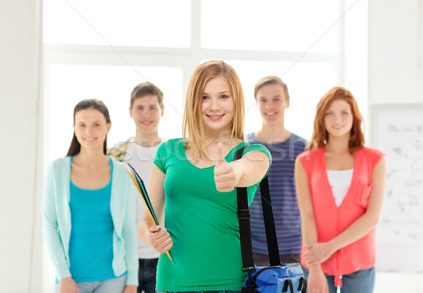 smiling students with teenage girl in front Stock photo © dolgachov