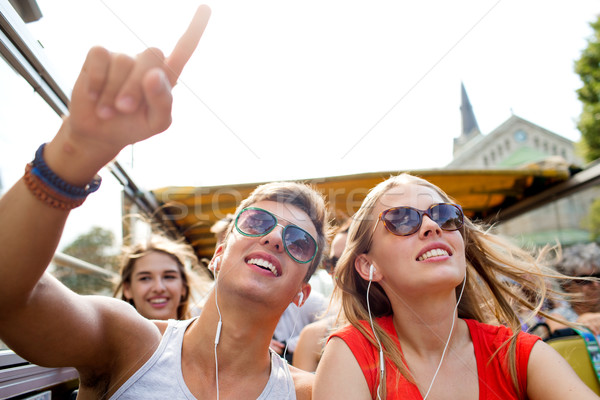 smiling couple with earphones traveling by bus Stock photo © dolgachov