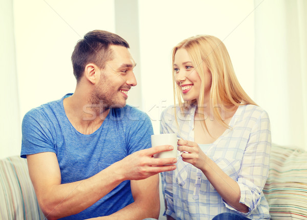 smiling man giving cup of tea or coffee to wife Stock photo © dolgachov