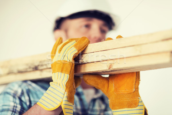 Stock photo: close up of male in gloves carrying wooden boards