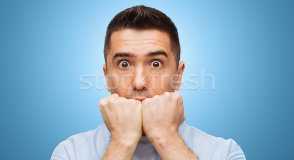 scared man face over blue background Stock photo © dolgachov