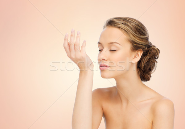 woman smelling perfume from wrist of her hand Stock photo © dolgachov