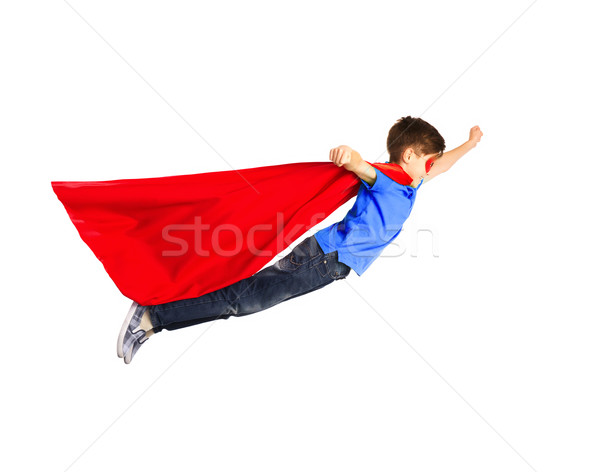 boy in red superhero cape and mask flying on air Stock photo © dolgachov